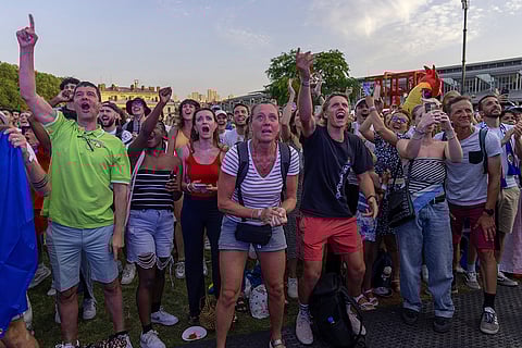 Spectators celebrate from a fan zone as Leon Marchand participates in men's 200-meter final